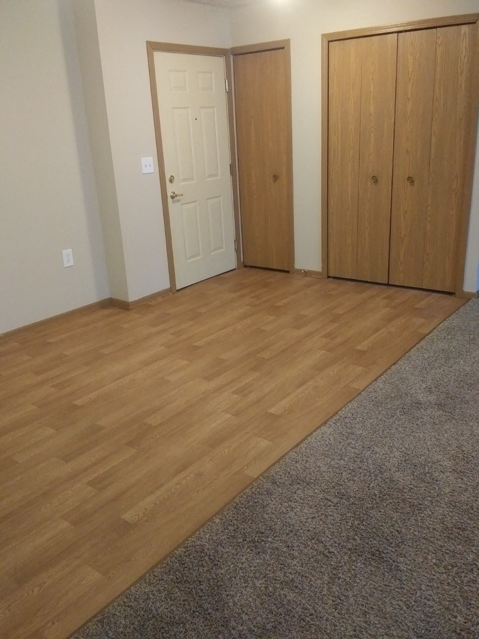 a room with a hard wood floor and two doors