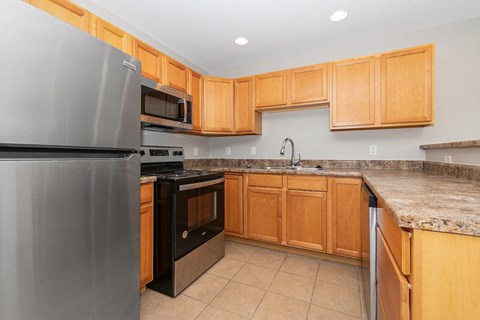 A kitchen with wooden cabinets and a granite countertop.