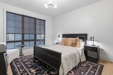 A bedroom with a large bed and a window overlooking the water.