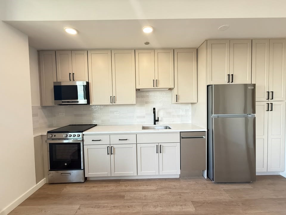 A kitchen with a stainless steel refrigerator, microwave, oven, and sink.at The Nest at Lincoln Park West, Chicago Illinois