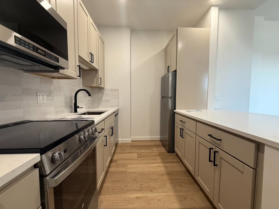 A kitchen with a black stove top oven and white cabinets.at The Nest at Lincoln Park West, Chicago Illinois