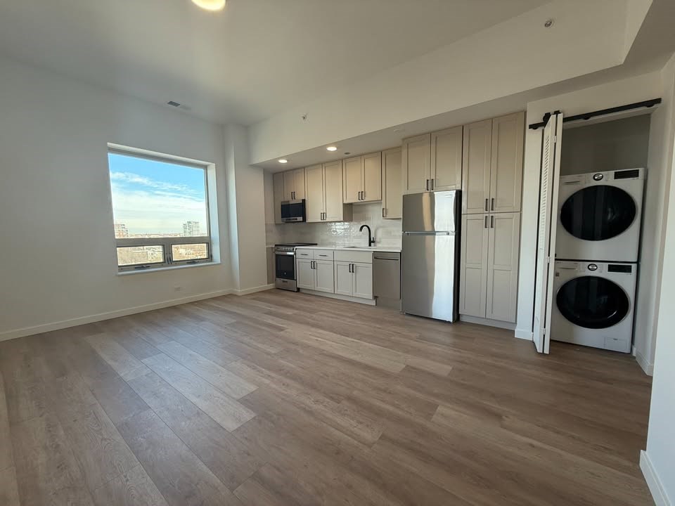 A kitchen with a refrigerator, microwave, and oven is shown.at The Nest at Lincoln Park West, Illinois