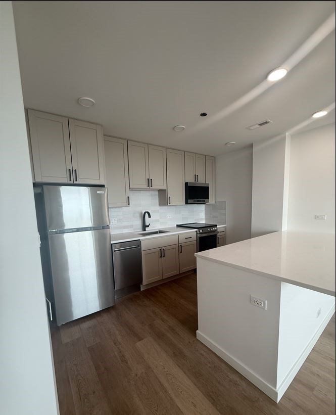 A kitchen with white cabinets and a white island.at The Nest at Lincoln Park West, Chicago, IL 60614