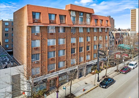 A red brick building with a balcony on the top floor.