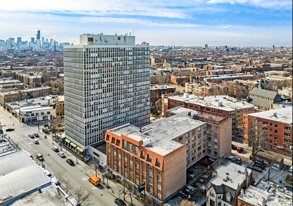A cityscape with a large building in the foreground and a skyline in the background.