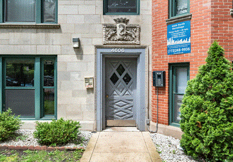 A building with a grey door and a number 4606 on it.