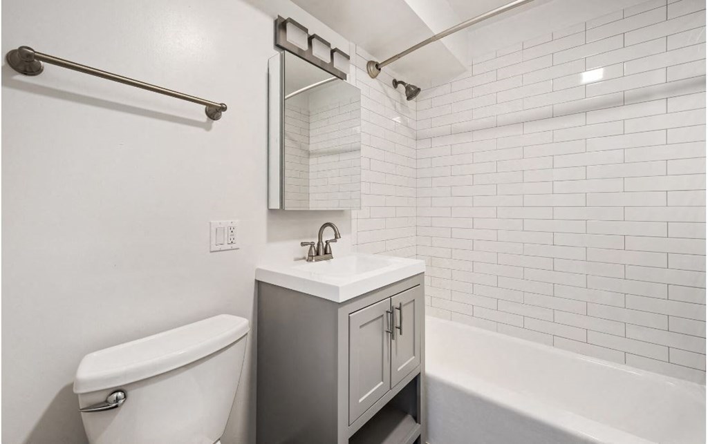 A white bathroom with a toilet, sink, and a bathtub.