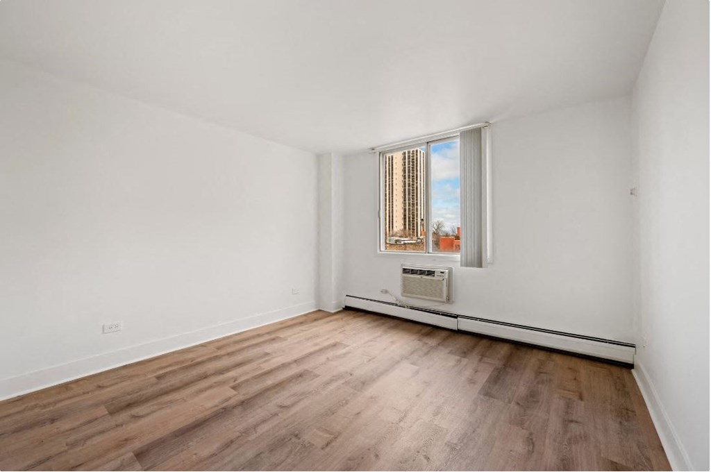 A room with a window and a radiator on the wall.