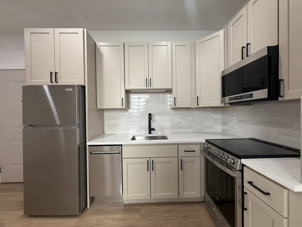 A kitchen with white cabinets and a stainless steel refrigerator.at The Nest at Lincoln Park West, Chicago, 60614