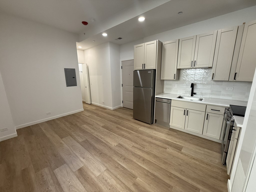 A kitchen with wooden floors and white walls.at The Nest at Lincoln Park West, Chicago Illinois