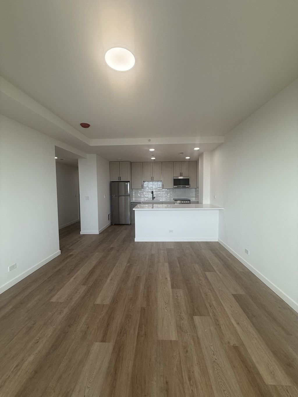A kitchen with a white counter and wooden floors.at The Nest at Lincoln Park West, Illinois, 60614