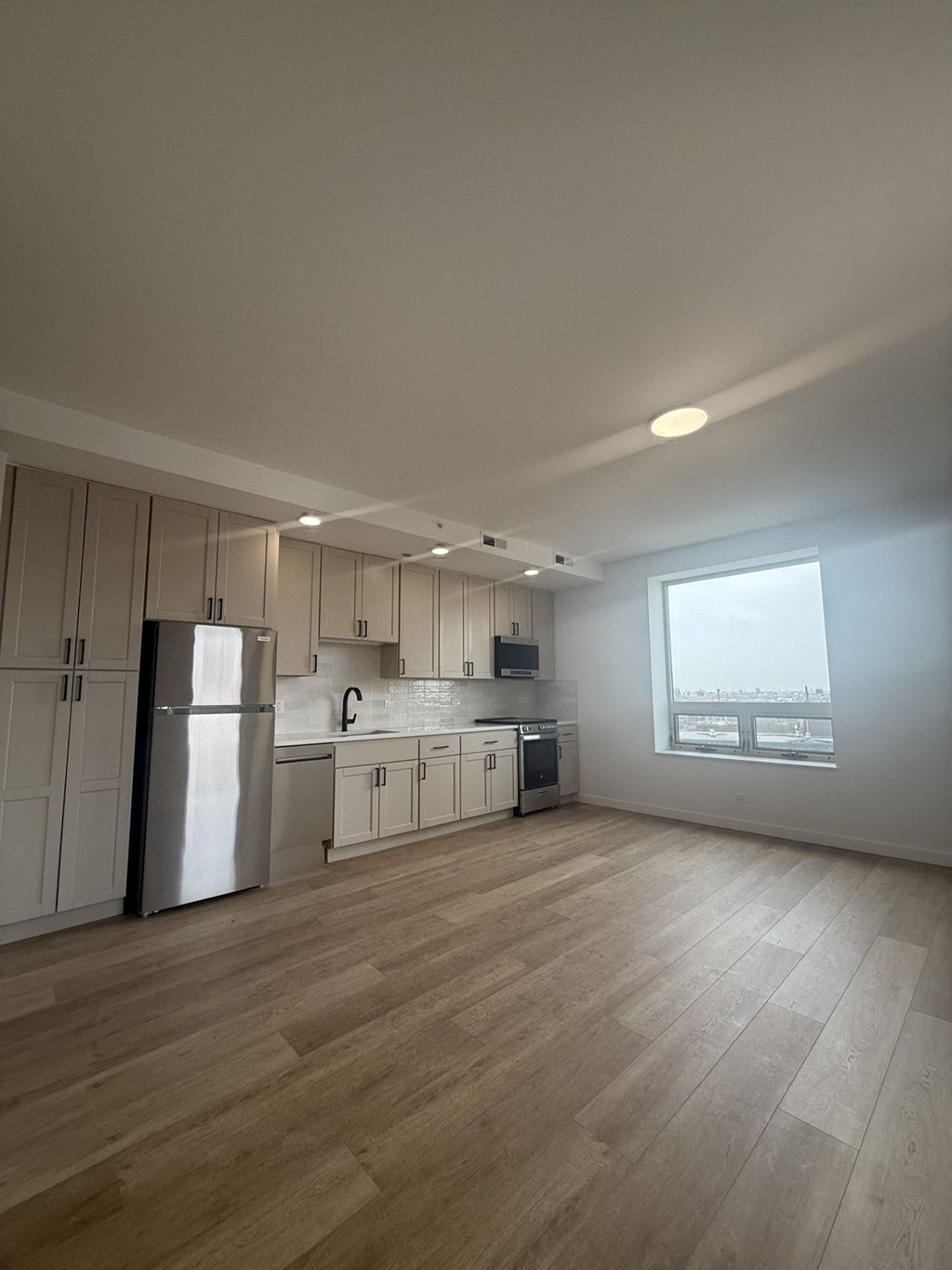 A kitchen with a refrigerator, sink, and cabinets.at The Nest at Lincoln Park West, Chicago, 60614