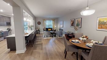 A well-lit, spacious kitchen and dining area with wooden floors and furniture.
