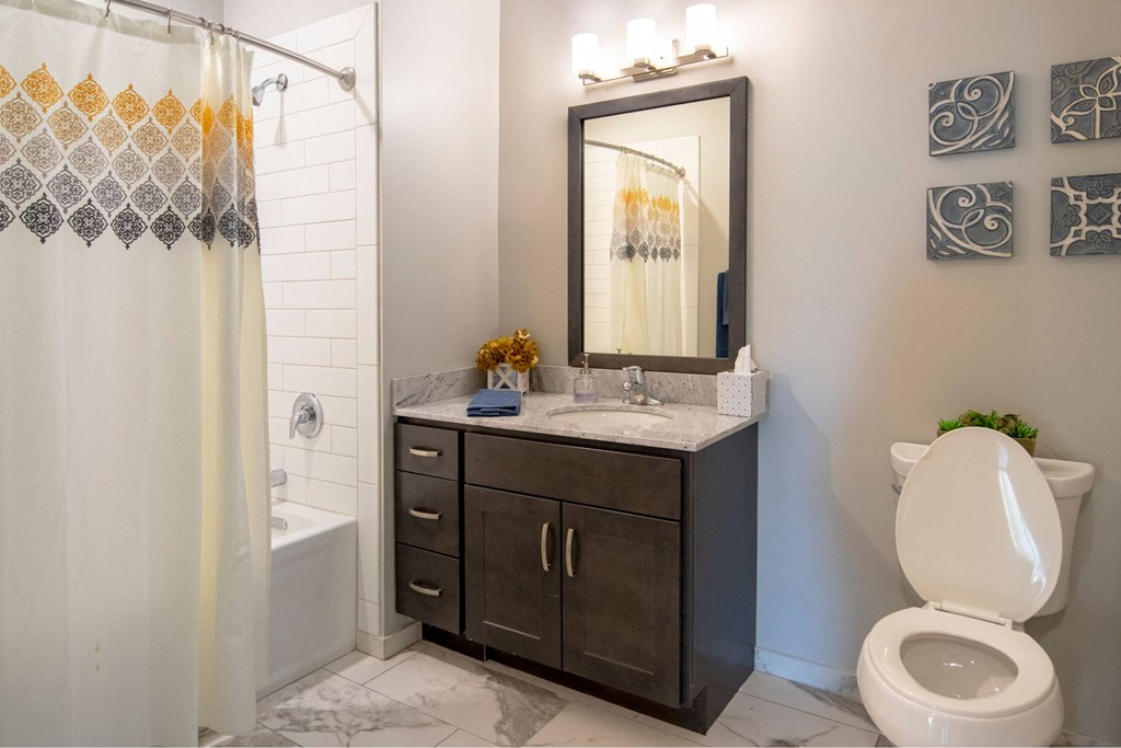 A bathroom with a toilet, sink, and shower.