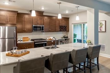 A kitchen with a large island and chairs.