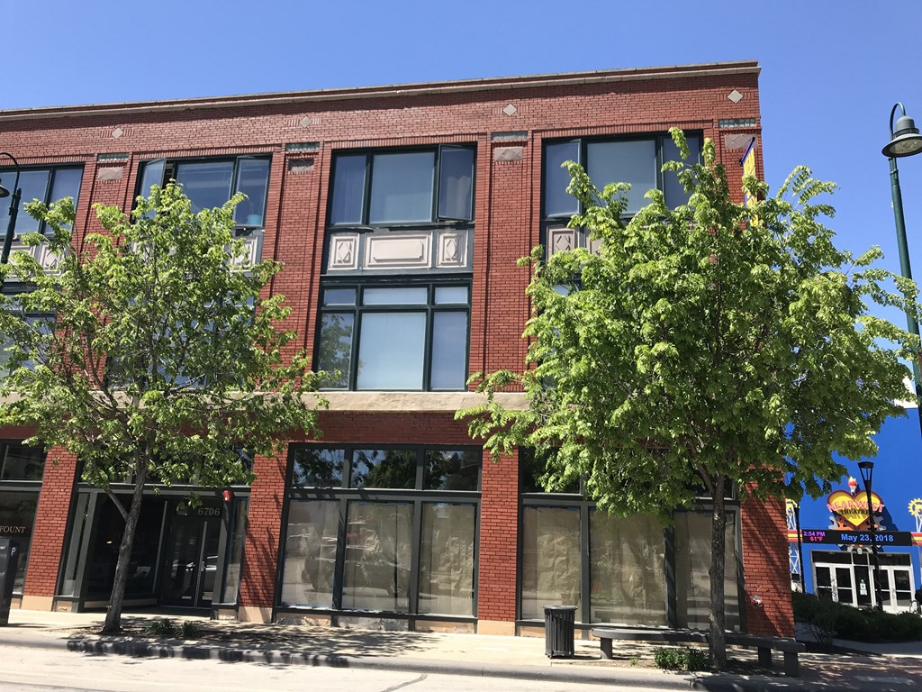 a red brick building with two trees in front of it