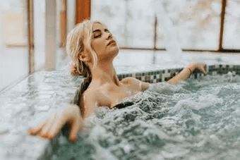 A woman is relaxing in a hot tub.