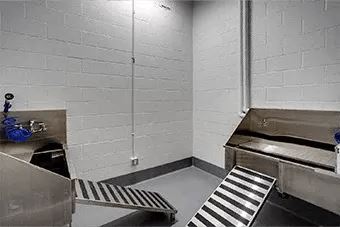 A white room with a metal staircase and a bench.