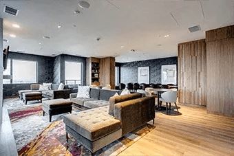 A modern living room with a variety of seating options and a wooden floor.