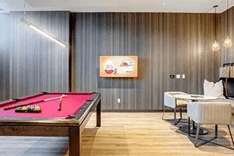 A pool table with a red cloth and a billiard cue on it.