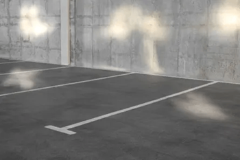 A parking lot with white lines on a concrete floor.