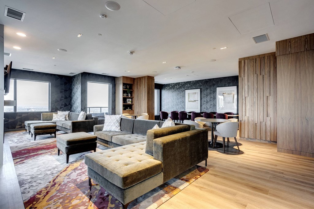 A modern living room with a grey sofa set and a wooden floor.