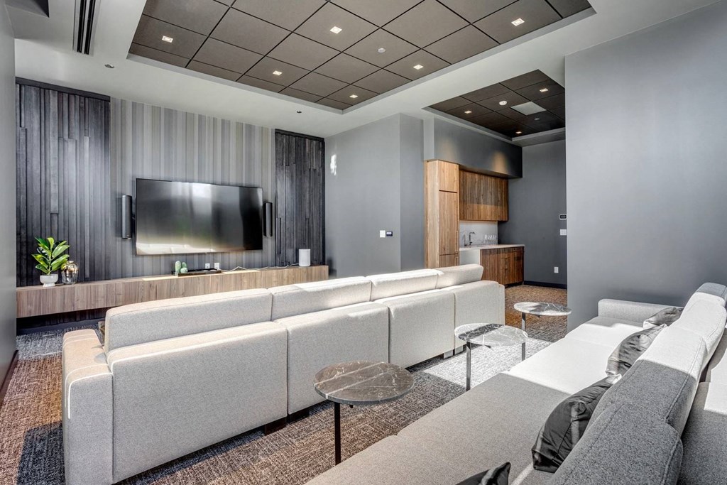 A modern living room with a grey sofa set and a television.