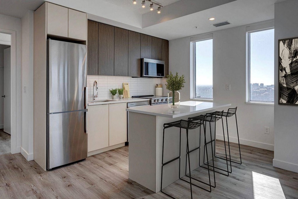 A modern kitchen with a large island and stainless steel appliances.