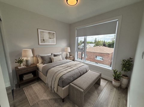 A bedroom with a large bed and a window overlooking a building.