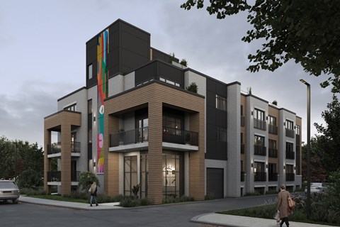 A modern apartment building with a person walking in front.