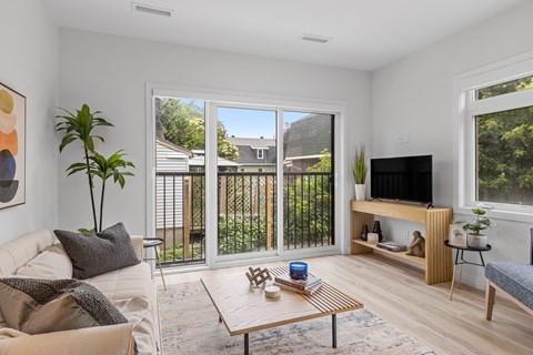 A living room with a couch, a coffee table, and a television.