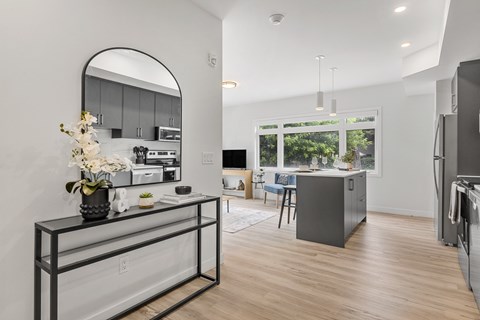 A modern kitchen with a large island and a fridge.