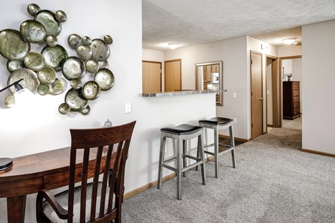 A dining room with a wooden table and chairs.