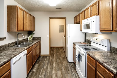 A kitchen with wooden cabinets and white appliances.
