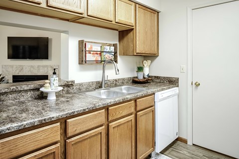 A kitchen with wooden cabinets and a granite countertop.