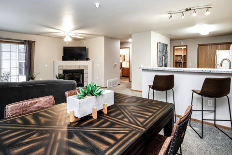 A living room with a black and gold patterned table in the center.