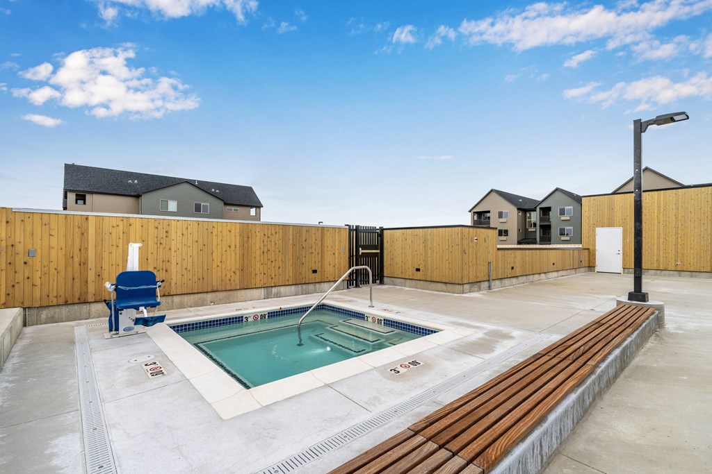 A small pool with a blue chair and a wooden fence.
