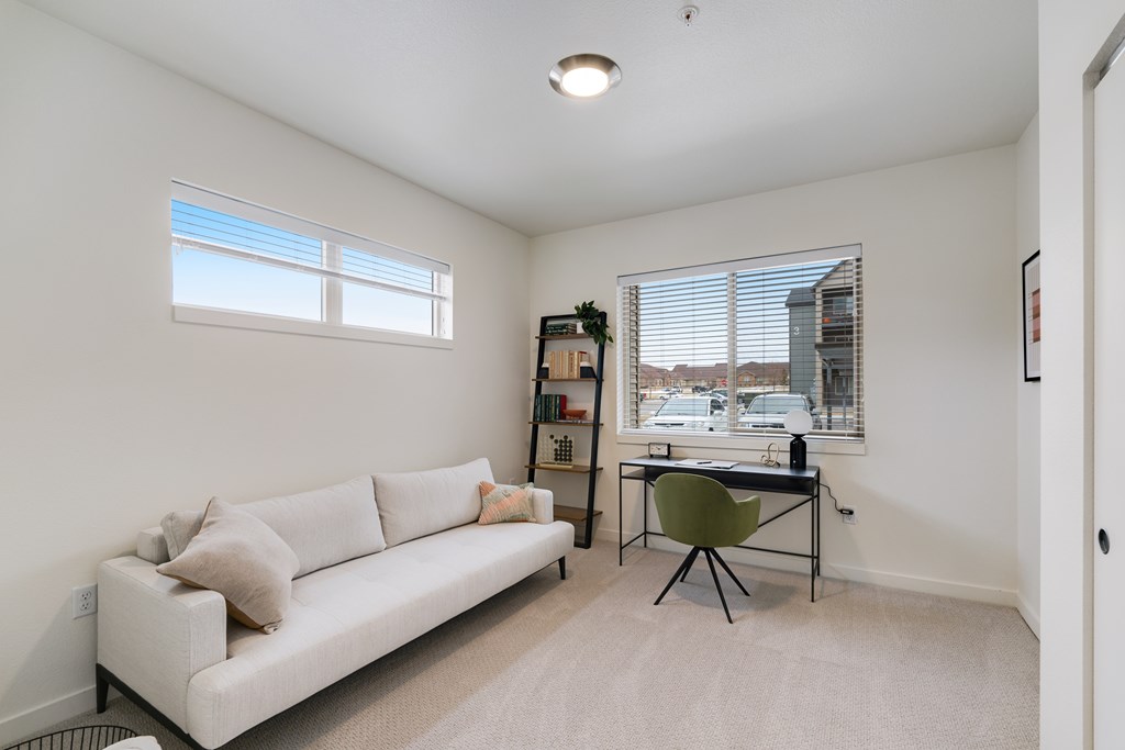 A living room with a white couch and a green chair.