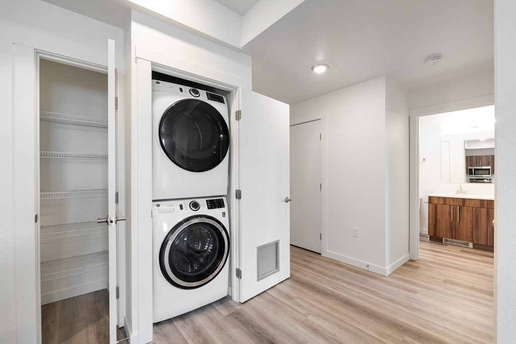 A white washing machine is in a white cabinet.