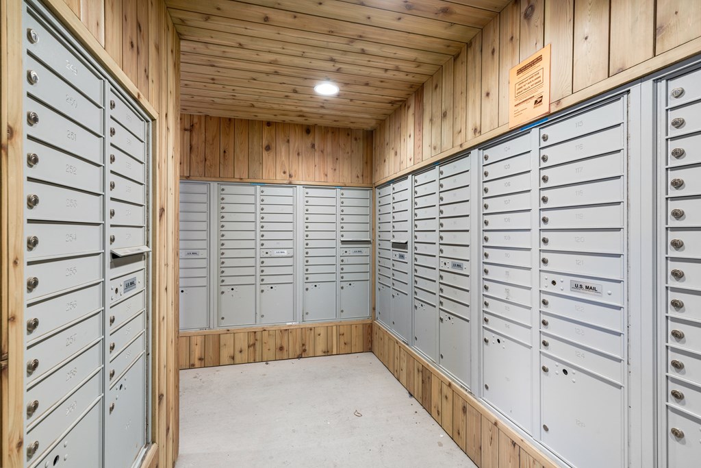 A room with wooden walls and ceiling and a long row of metal lockers.