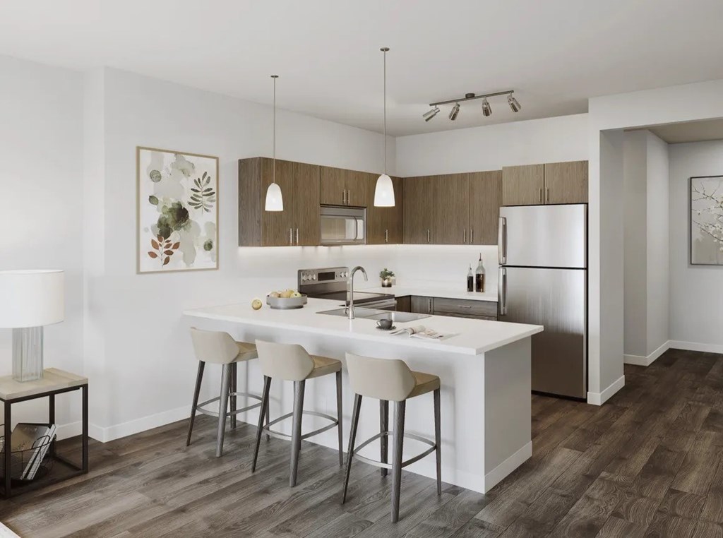 A modern kitchen with white countertops and a refrigerator.