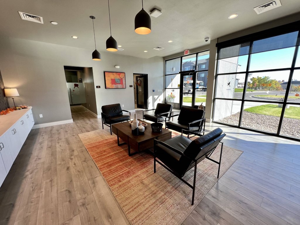 A modern living room with a black leather chair and a wooden floor.