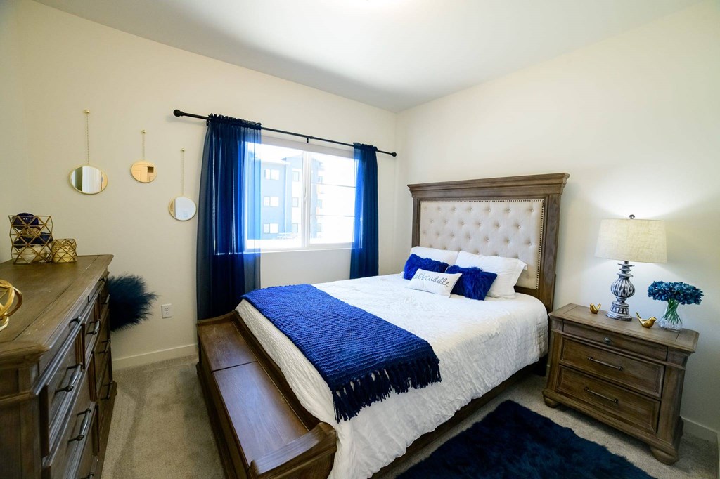 A bedroom with a large bed and a wooden dresser.