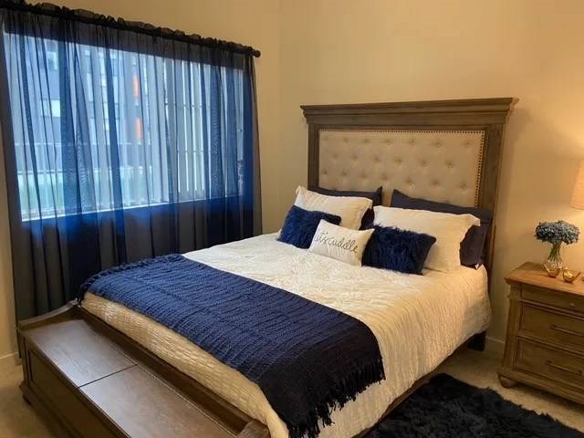 A bed with a white and blue comforter and pillows with the word "Prudential" written on them.