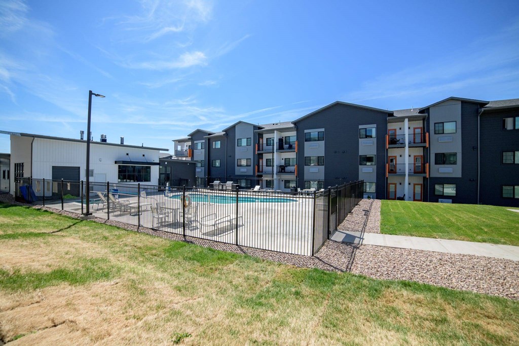 A row of modern townhouses with a pool in the backyard.