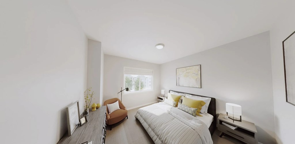 A bedroom with a large bed and a brown chair.