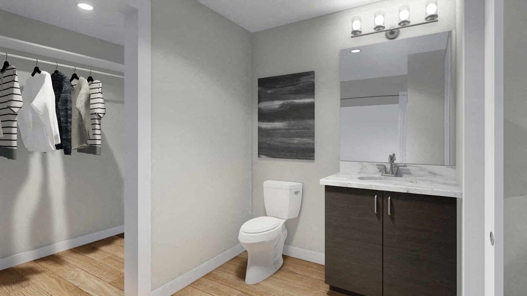 A bathroom with a toilet, sink, and a mirror.