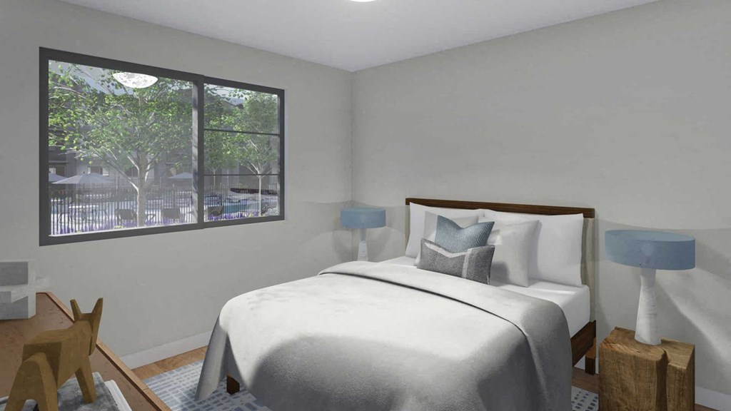 A bedroom with a large bed and a view of trees outside the window.