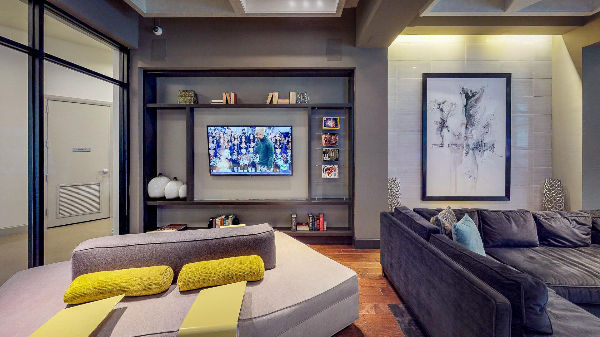 A modern living room with a grey couch and a television.