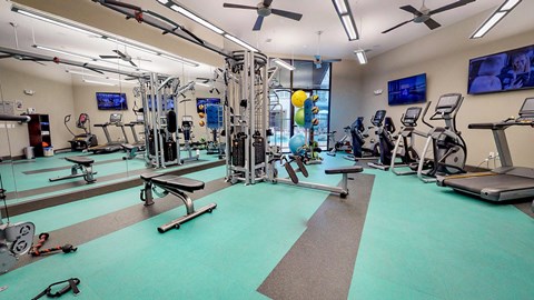 Gym with a variety of equipment including treadmills, weights, and exercise machines at Civic at Frisco Square Apartments, Frisco, Texas